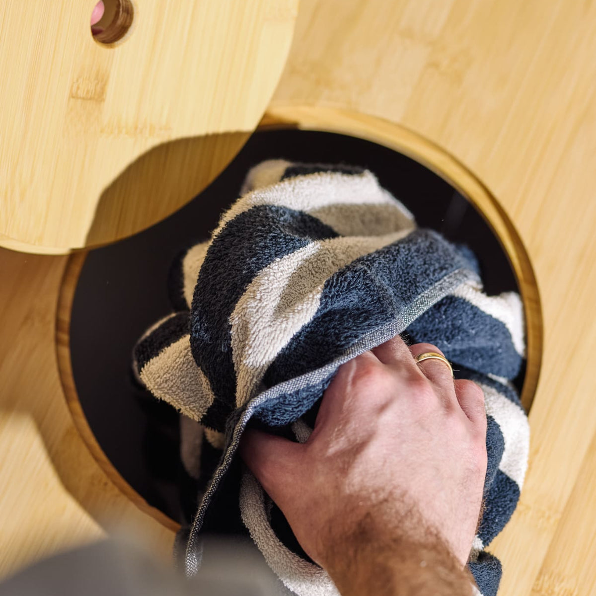Mit einer Hand den Deckel öffnen, mit der anderen Wäsche einwerfen – so verschwindet alles direkt in der Wanne und bleibt außer Sicht.